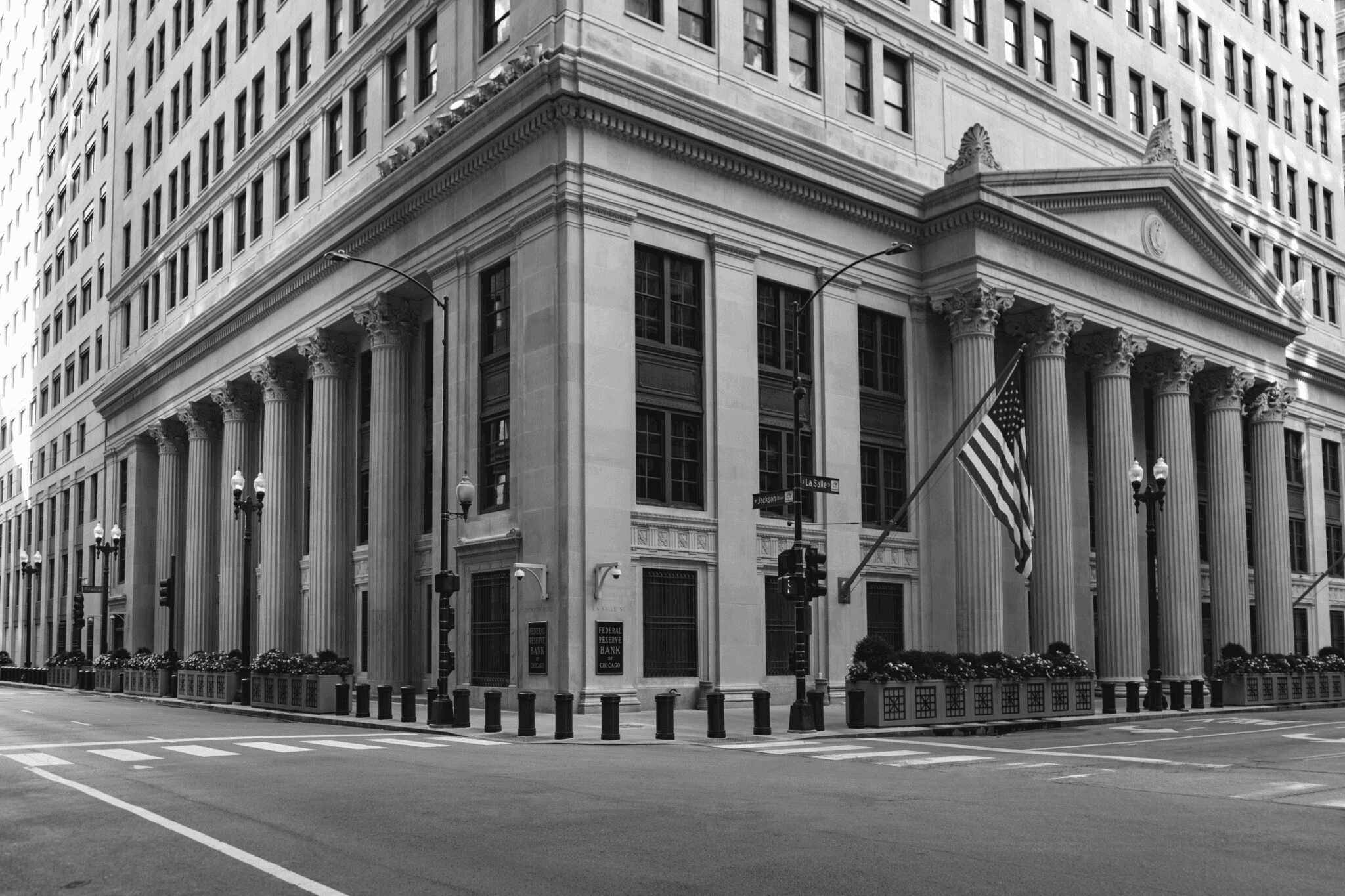 Black-and-white photo of the Federal Reserve Bank of Chicago with columns and flag.